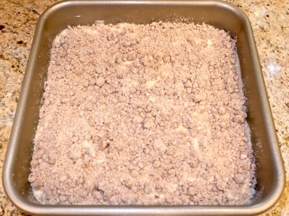 Crumb cake in pan with crumbs