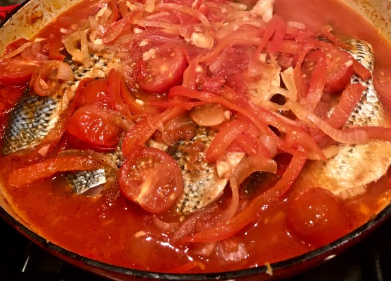 sea bass in liquid covered with sauce